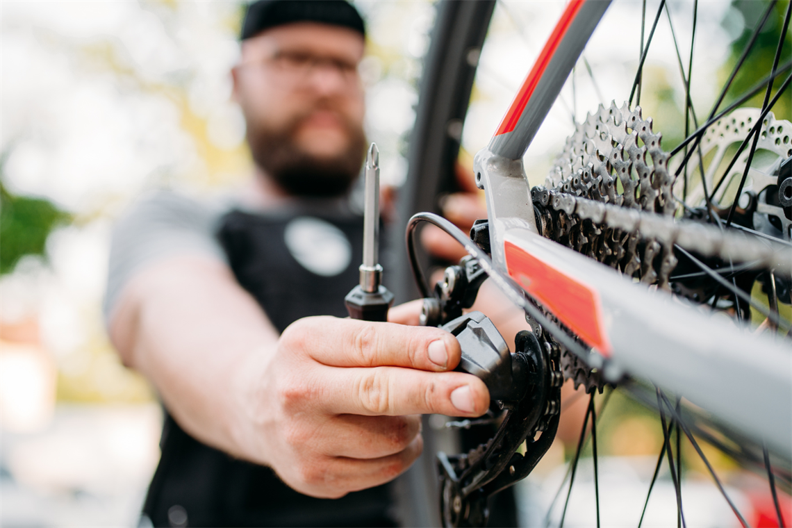A man working on bicycle using screwdriver